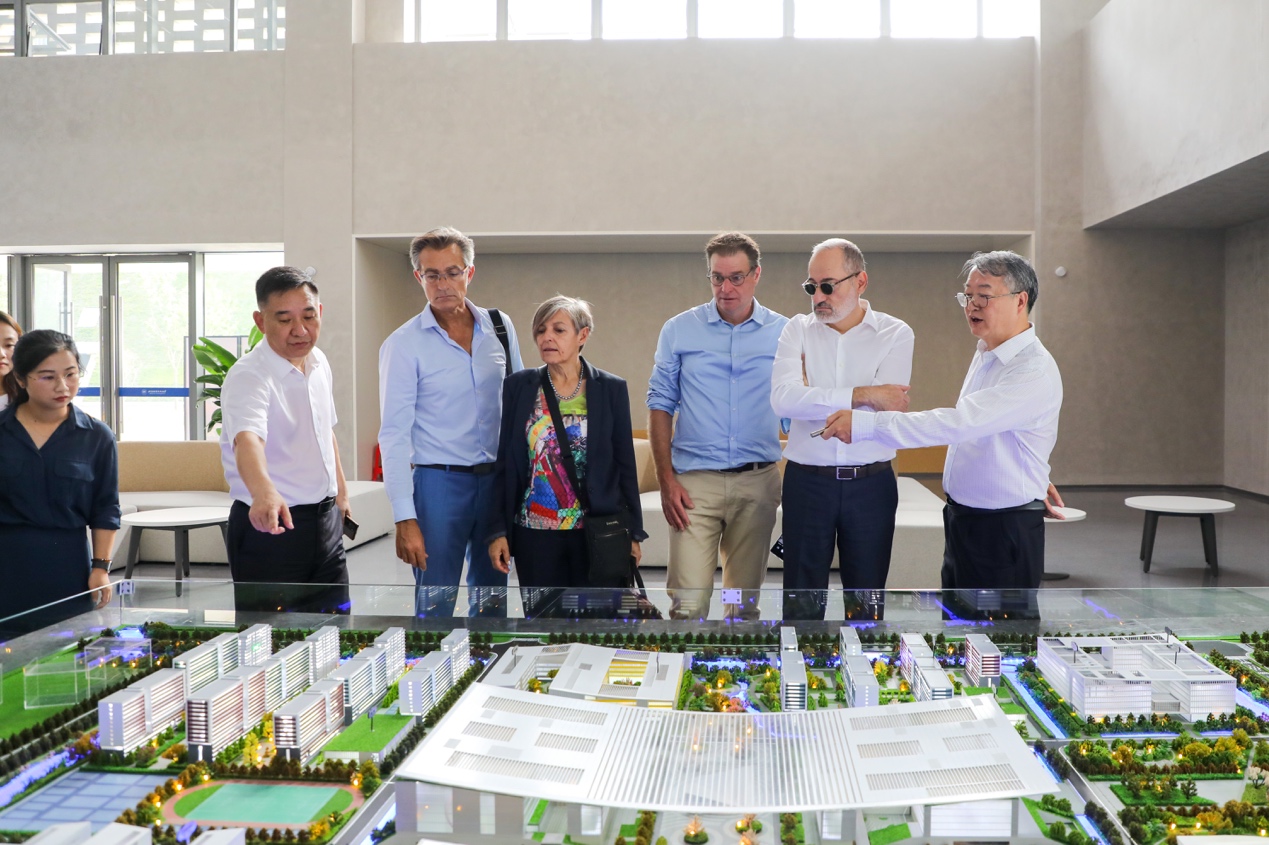 一群人站在桌子边 描述已自动生成